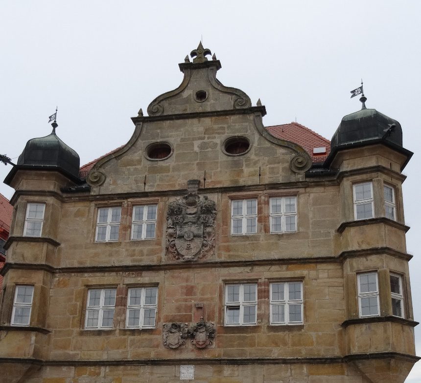 Das Bild zeigt das Deutschordensschloss in Eschenbach, sowie rechts dasvon einen Teil des alte Rathauses und links einen Teil des Liebfrauenmünsters, die Stadtpfarrkirche der Gemeinde.