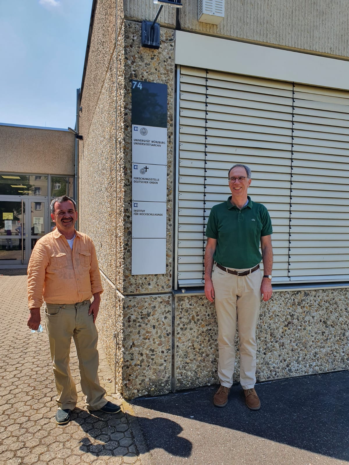 Das Bild zeigt den neuen Universitätspräsidenten sowie den Leiter der Forschungsstelle des Deutschen Ordens vor dem Gebäude der Forschungsstelle in Würzburg.