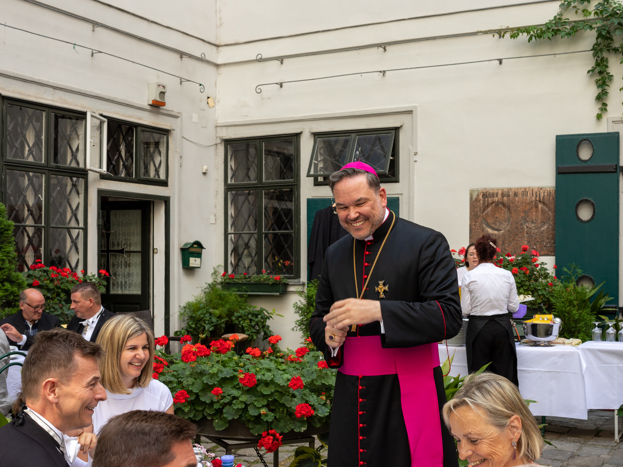 Das Bild zeigt den 66. Hochmeister Frank Bayard in Gesellschaft anderer Menschen.