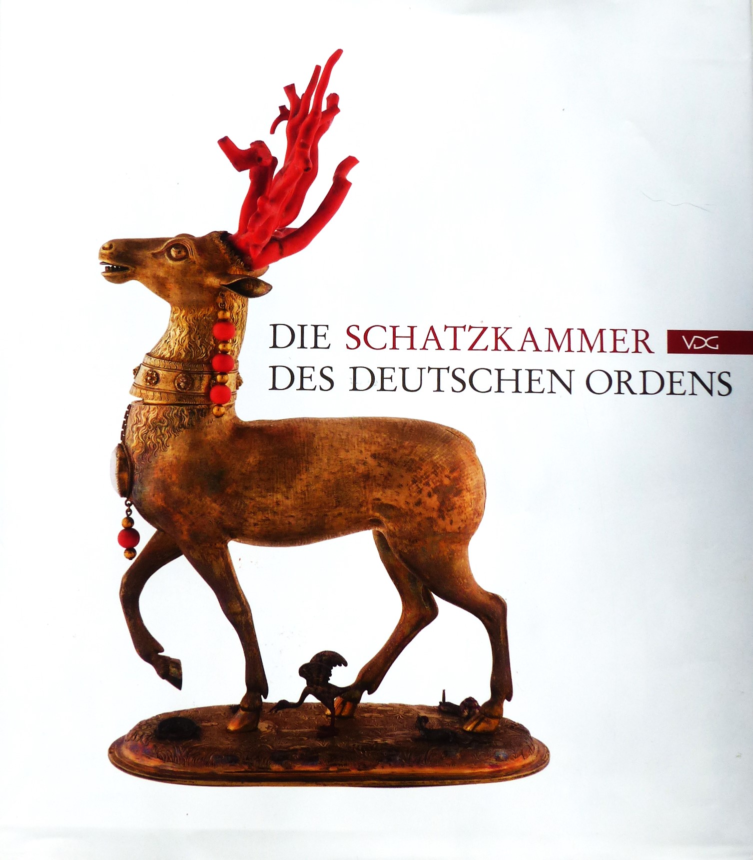 Das Bild zeigt das Cover des Katalogs: "Die Schatzkammer des Deutschen Ordens" auf dem eine Statue eines Hirsches abgebildet ist.