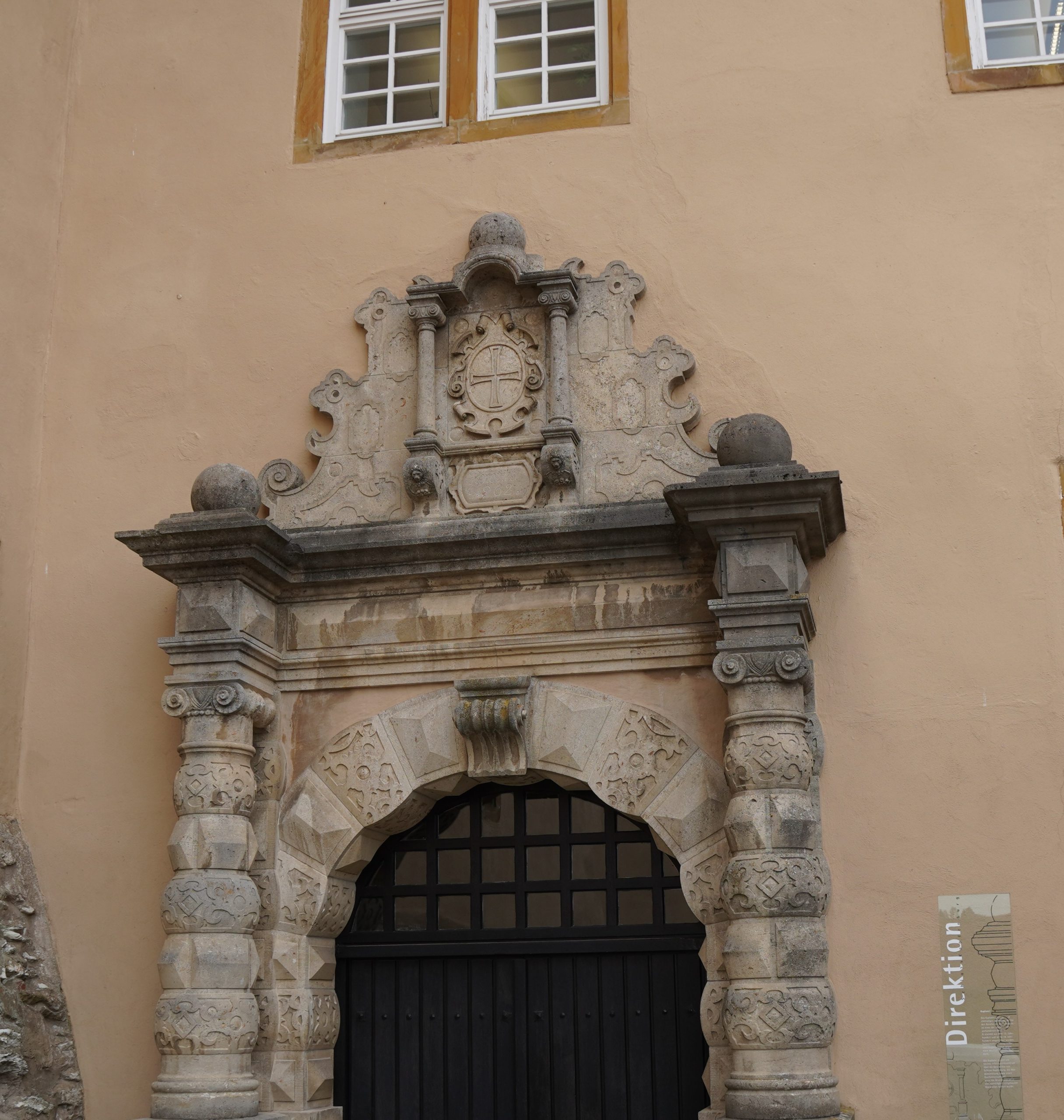 Das Bild zeigt ein Portal des Schlosses "Kapfenburg", an dem ein Deutschordenskreuz angebracht ist.