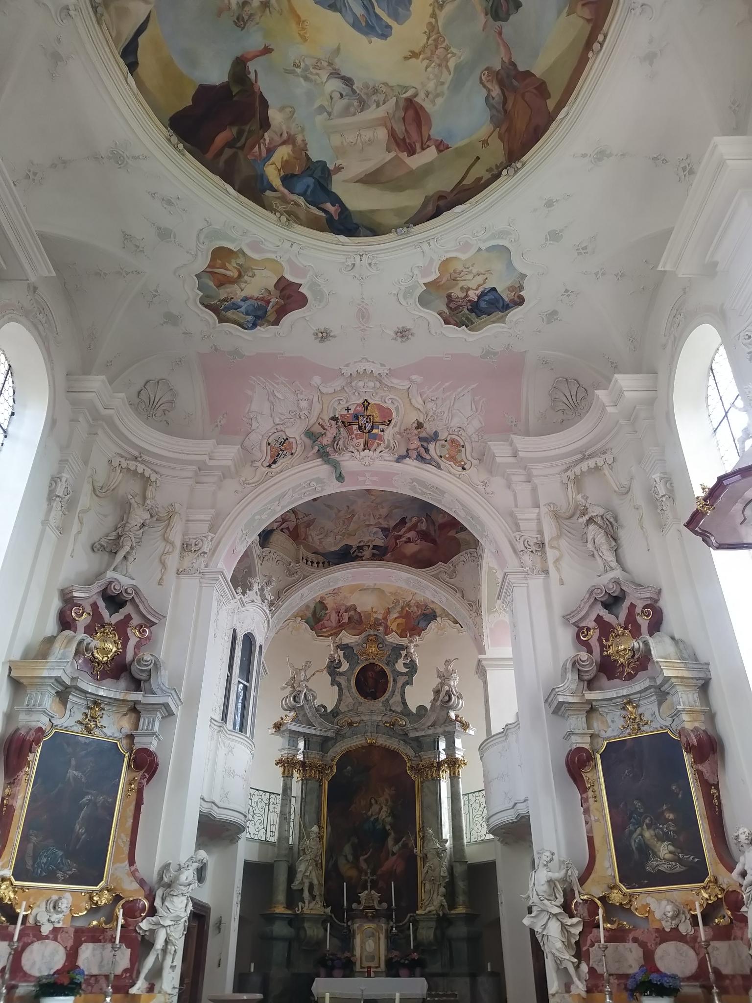 Das Bild zeigt den Innenraum der Deutschordenskirche in Mainau mit Decken- und Wandgemälde und dem Altarraum.