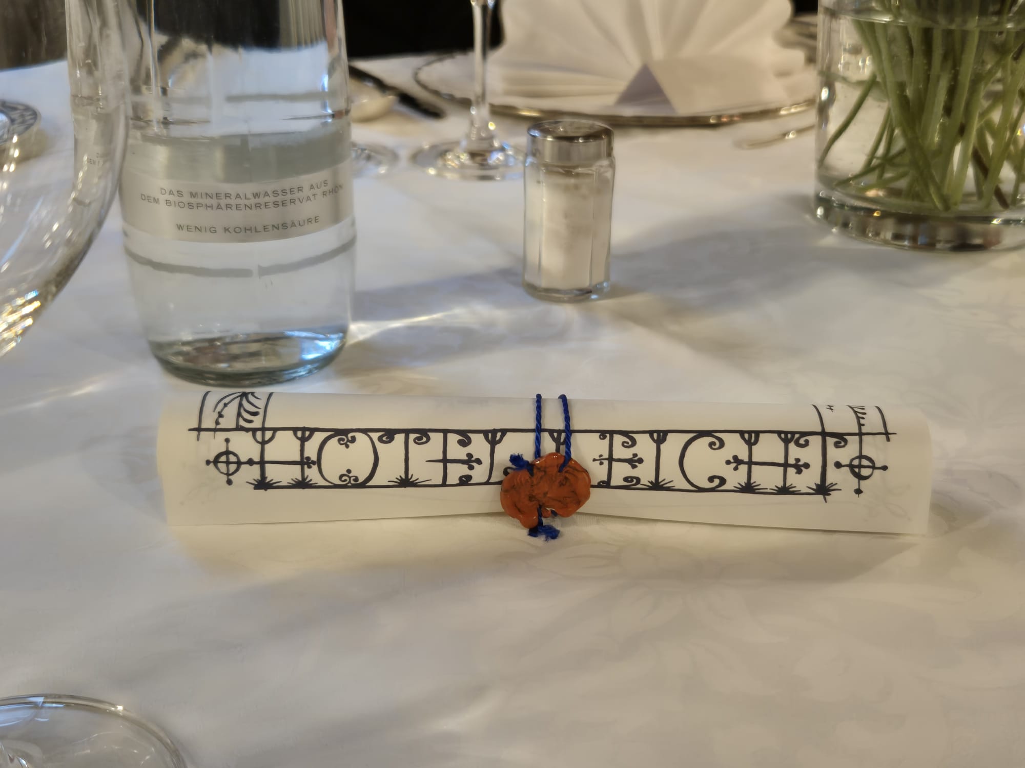 Das Bild zeigt ein zusammengerolltes Schriftstück mit einem Siegel.