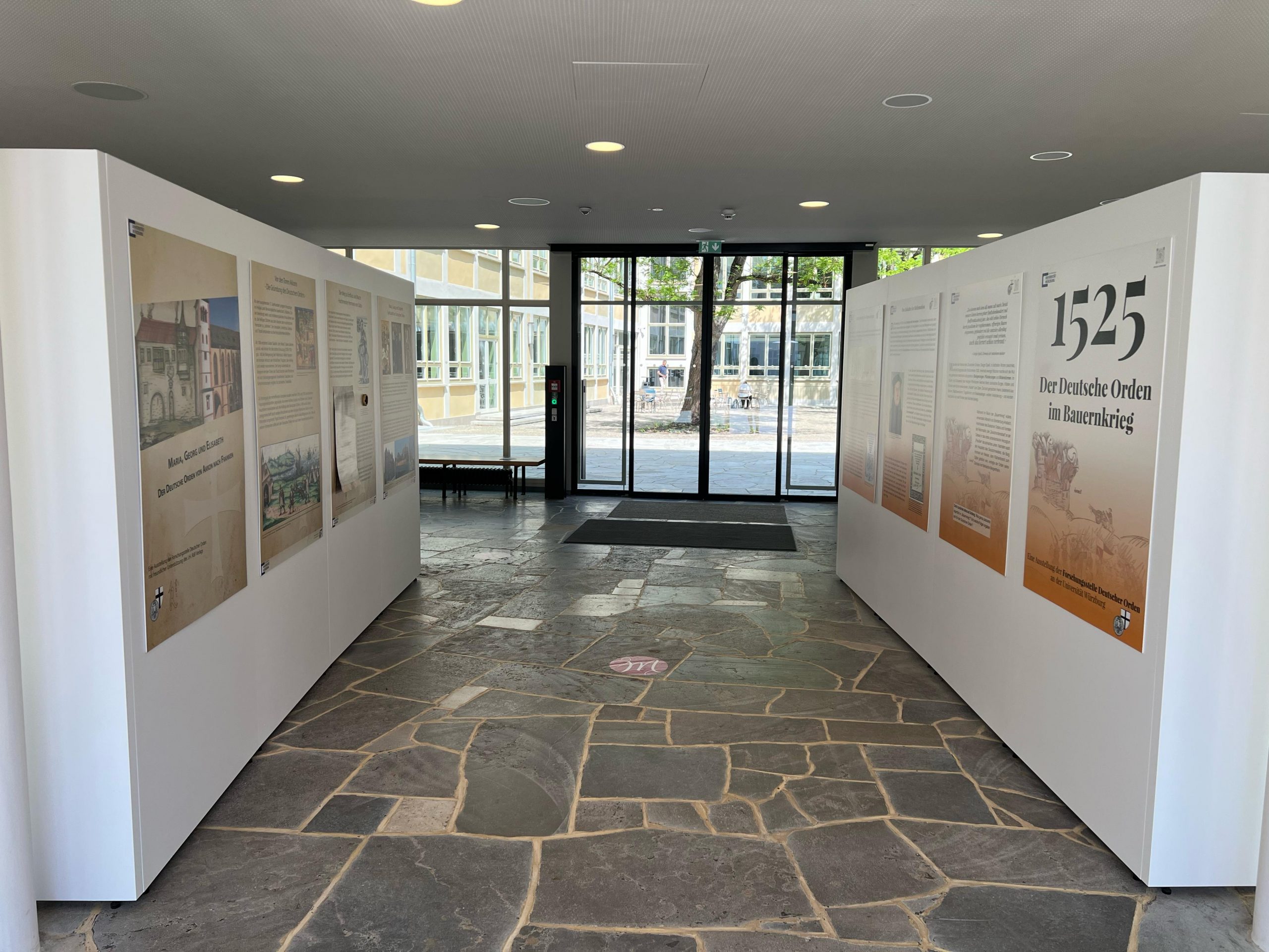 Das Bild zeigt Tafeln der Ausstellung "1525 - Der Deutsche Orden im Bauernkrieg", die im Mozartareal in Würzburg hängen.